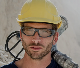 Ouvrier portant un casque et des lunettes de protection Bollé Safety sur un chantier de BTP.