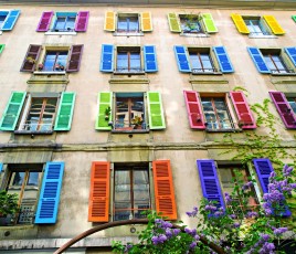 Façade d'une maison avec des volets en bois de couleur.