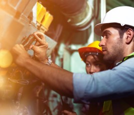 Technicien de maintenance intervenant sur des conduites industrielles dans une usine.