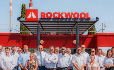 Personnel Rockwool devant le logo Rockwool.