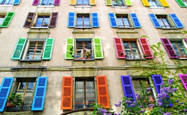 Façade d'une maison avec des volets en bois de couleur.