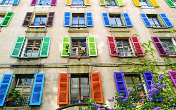 Façade d'une maison avec des volets en bois de couleur.