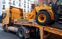 Camion Kiloutou livrant une pelleteuse sur un chantier à Paris.