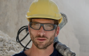 Ouvrier portant un casque et des lunettes de protection Bollé Safety sur un chantier de BTP.